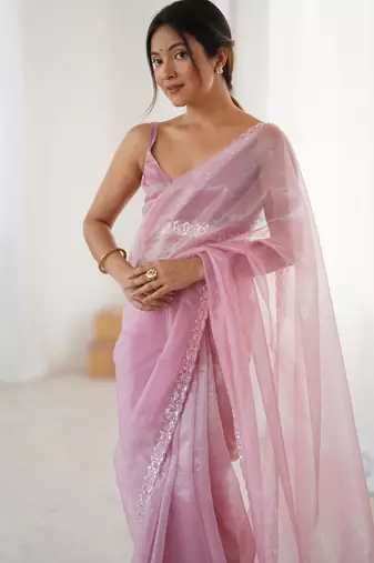 Pink net embellished saree with unstitched blouse piece.