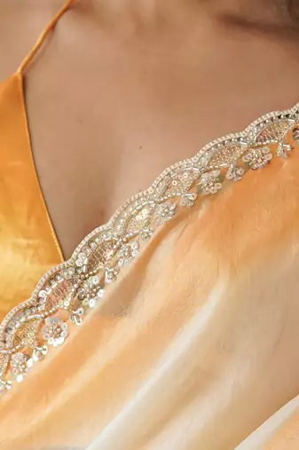 Yellow tissue satin embellished saree with unstitched blouse piece.