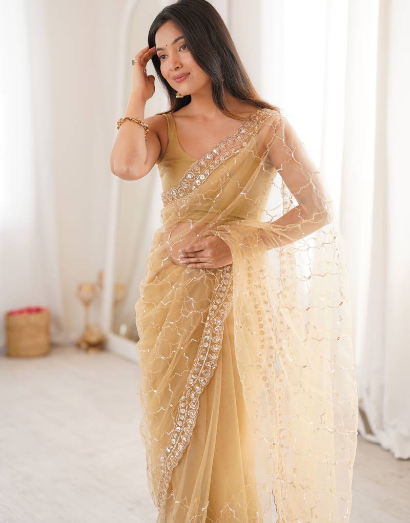 Chiku net embellished saree with unstitched blouse piece.