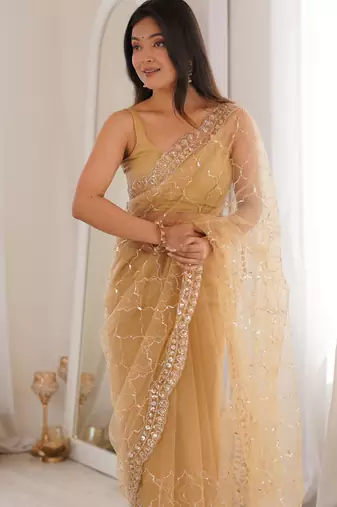 Chiku net embellished saree with unstitched blouse piece.