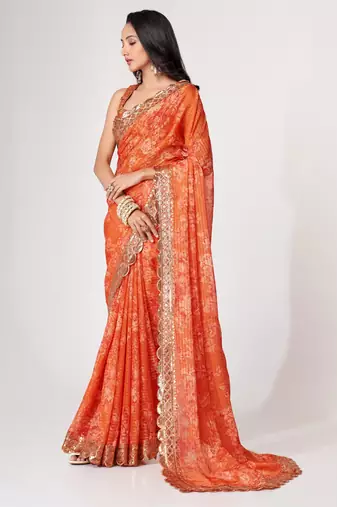 Rich coral-orange gold sequin and zari-style embroidered delicate tonal floral printed indian wedding Saree