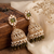 Rose gold plated light green  stone  studded dome jhumka earrings with pearls