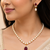 Pearl necklace and earring set with ruby pendant cz baguette accents, gold-tone spacers, drop earrings included.