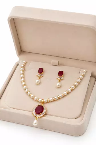 Pearl necklace and earring set with ruby pendant cz baguette accents, gold-tone spacers, drop earrings included.