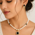 Pearl beaded necklace and earrings set with black stone pendant gold-tone finish, cz baguette accents, drop earrings.