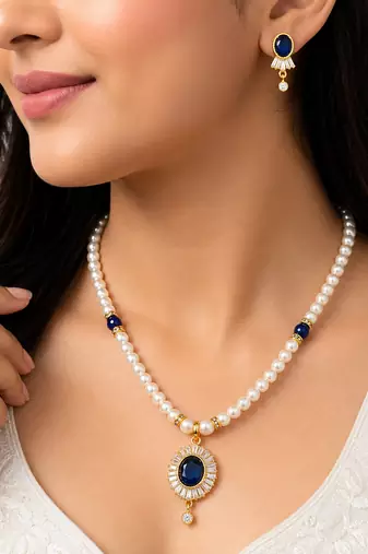 Pearl necklace and earring set with blue sapphire pendant gold-tone finish, cz baguette halo, blue stone accents.