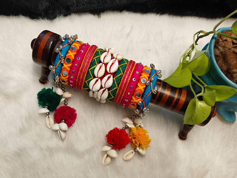  handcrafted multicolour navratri thread bangle set with cowrie shells & pom-poms