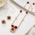 Gold-toned ruby red beaded pendant necklace and earrings set pearl accents, square cz pendant, festive wear, gold chain