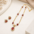 Red crystal & pearl pendant necklace and earrings jewellery set oval cz pendant, pearl beaded gold-tone finish.