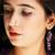 Gold plated purple drop dangler earrings