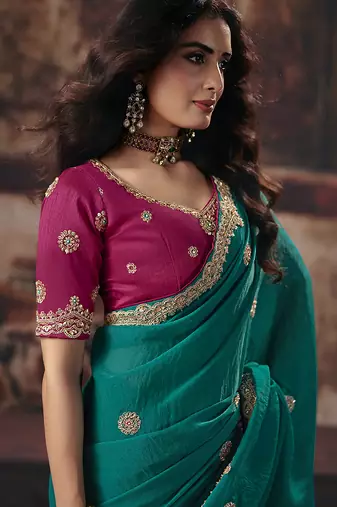Teal green faux chiffon saree with zari embroidered border & magenta pink blouse
