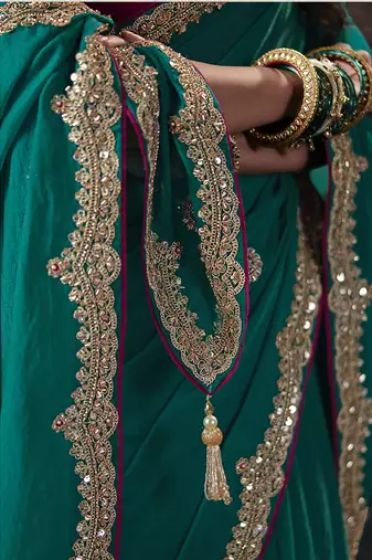 Teal green faux chiffon saree with zari embroidered border & magenta pink blouse