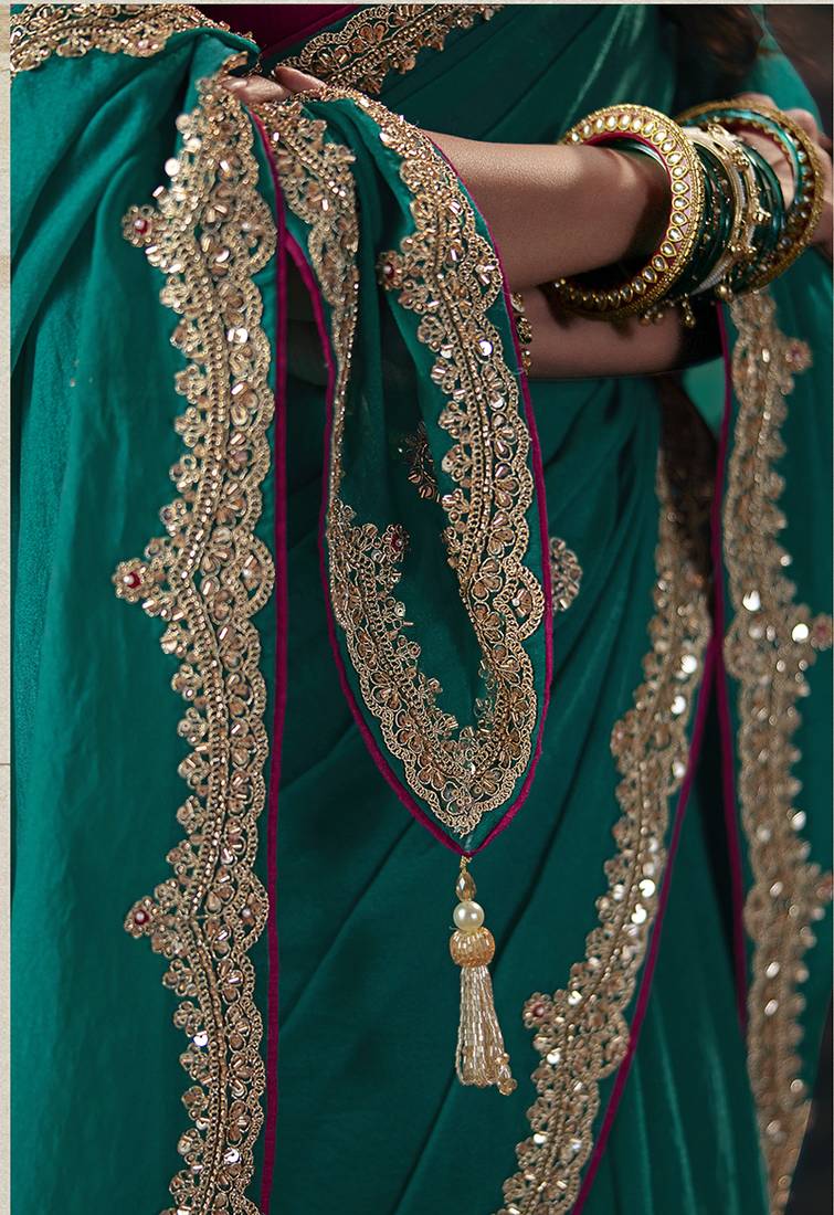Teal green faux chiffon saree with zari embroidered border & magenta pink blouse