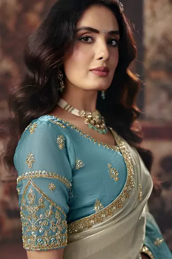 Cream & sky blue faux satin shimmer saree with embroidered blouse