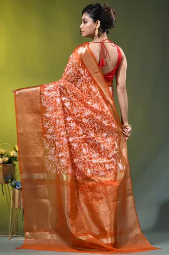 Elegant orange organza saree with white floral embroidery & rich golden zari border