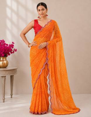 Orange bandhani printed saree with mirror work & cutwork border 1