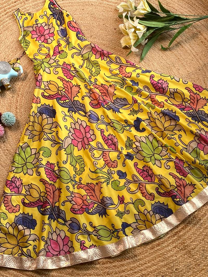 Yellow tussar silk gown for girls features a vibrant pen kalamkari floral print