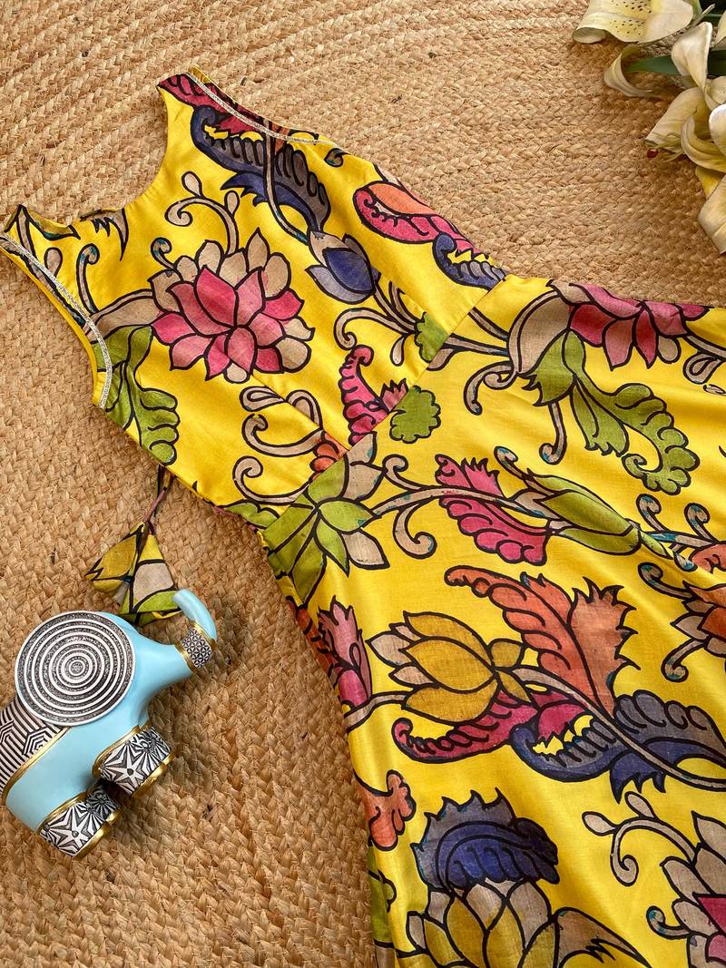 Yellow tussar silk gown for girls features a vibrant pen kalamkari floral print