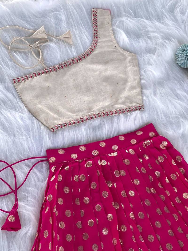 Pink one-shoulder solid crop top with polka dot flared lehenga for girls