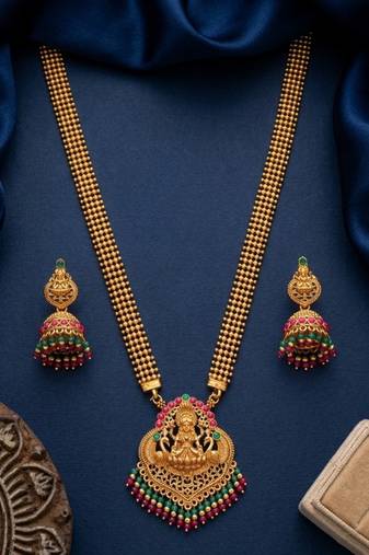 gold temple jewelry set with goddess lakshmi pendant, green & red beads & jhumkas 