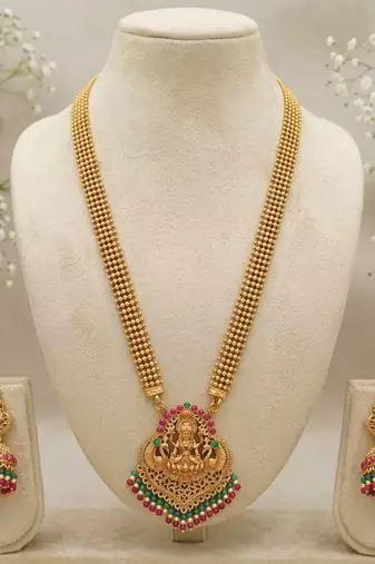 gold temple jewelry set with goddess lakshmi pendant, green & red beads & jhumkas 