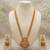 gold temple jewelry set with goddess lakshmi pendant, green & red beads & jhumkas 
