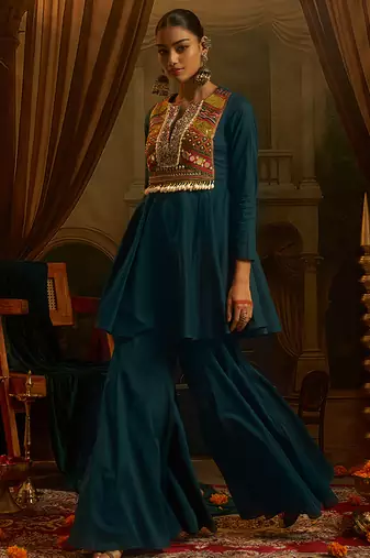 Teal blue mul cotton set with a long-sleeve flared peplum top, mirror-work embroidered yoke.