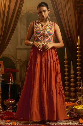 Elevate festive style with this rust orange gown featuring intricate mirror and thread embroidery.