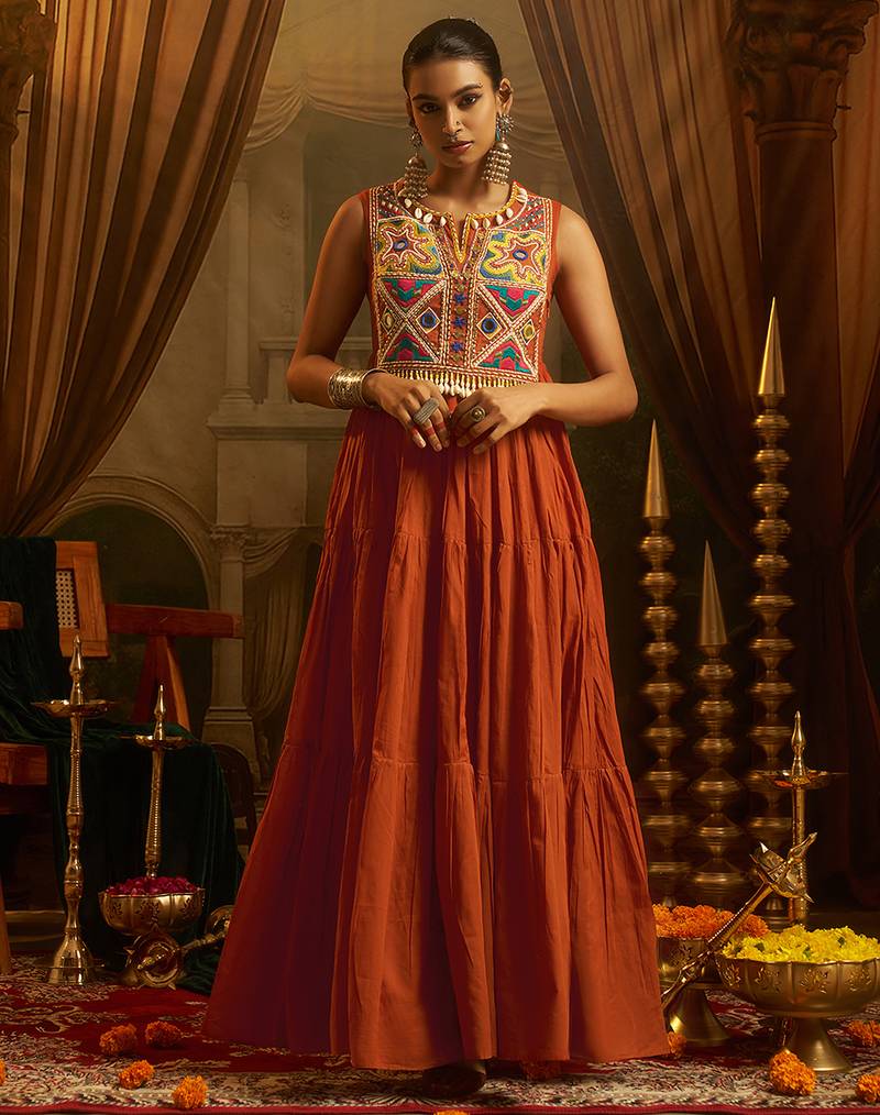 Elevate festive style with this rust orange gown featuring intricate mirror and thread embroidery.