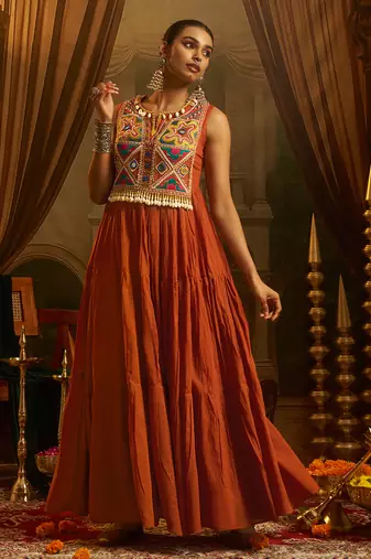 Elevate festive style with this rust orange gown featuring intricate mirror and thread embroidery.