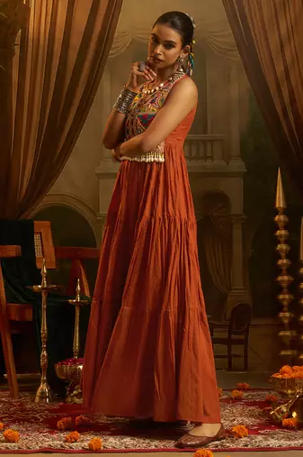 Elevate festive style with this rust orange gown featuring intricate mirror and thread embroidery.