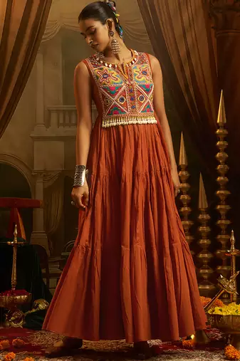 Elevate festive style with this rust orange gown featuring intricate mirror and thread embroidery.