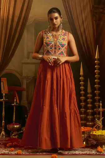 Elevate festive style with this rust orange gown featuring intricate mirror and thread embroidery.