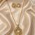 Elegant gold-tone teardrop pendant necklace set with matching stud earrings