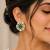 Emerald green teardrop stone gold-tone studded earrings