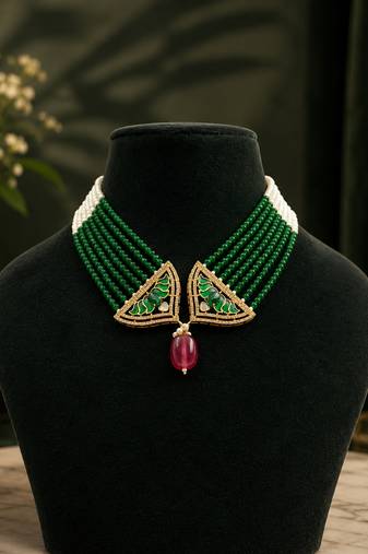 Elegant green beaded necklace with artistic pendant and ruby-tone drop