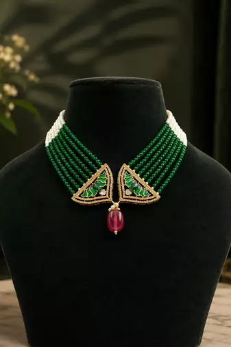Elegant green beaded necklace with artistic pendant and ruby-tone drop