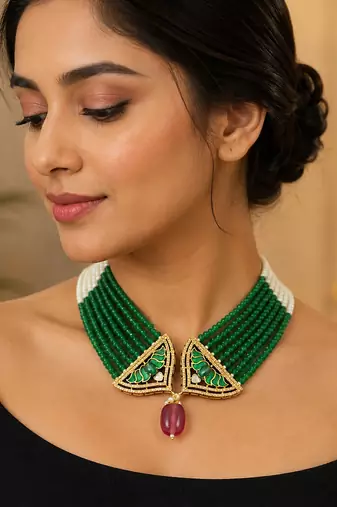 Elegant green beaded necklace with artistic pendant and ruby-tone drop