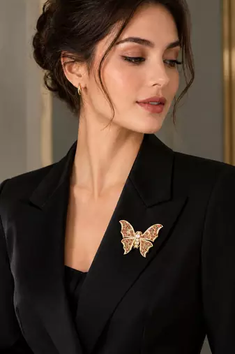 Elegant gold-plated butterfly brooch with pink and clear stone detailing