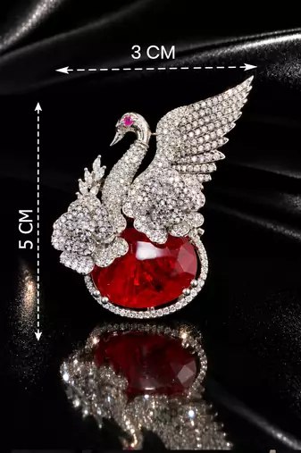 Elegant swan brooch with red crystal and wing shaped cz stone detailing
