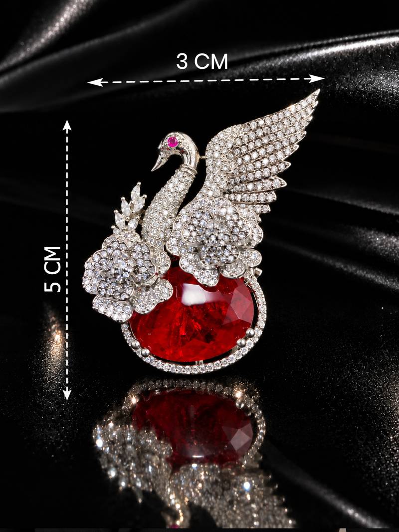 Elegant swan brooch with red crystal and wing shaped cz stone detailing