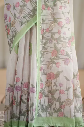kusumita linen saree with hand painted flowers. sequence work over them. blouse fabric given inside the saree.