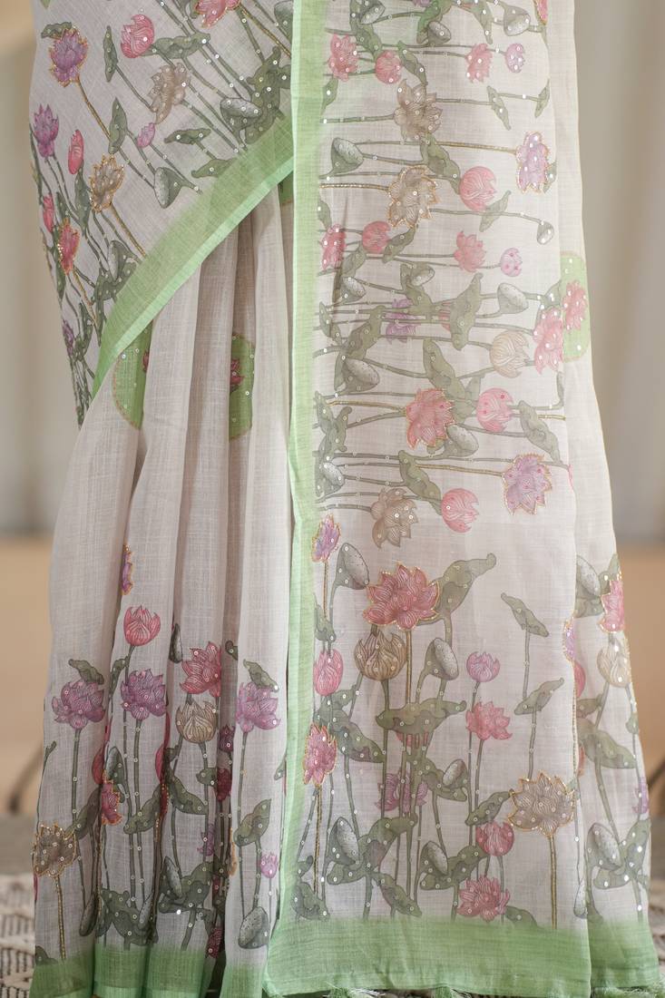 kusumita linen saree with hand painted flowers. sequence work over them. blouse fabric given inside the saree.