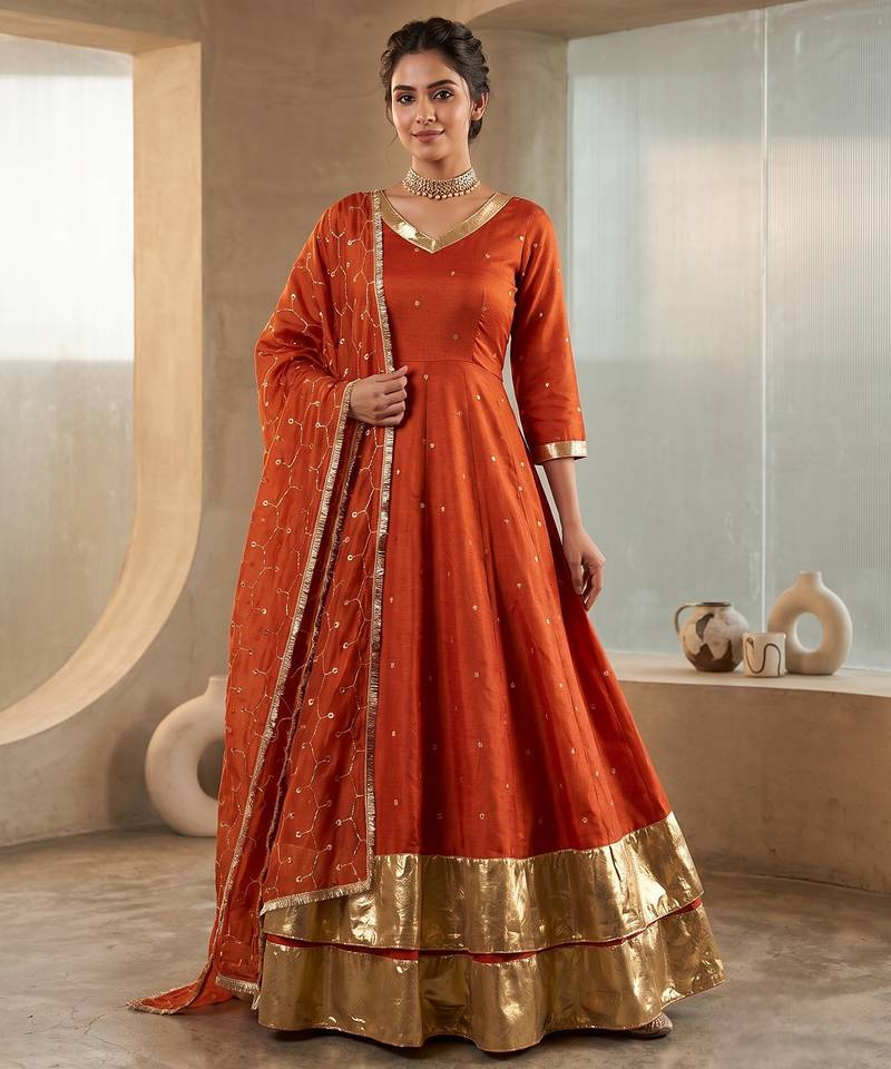 Rust orange silk anarkali suit with golden border and embroidered dupatta