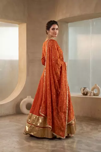 Rust orange silk anarkali suit with golden border and embroidered dupatta