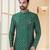 Green heavy jacquard sherwani set with full zari embroidery, minimal detailing, and fancy buttons.