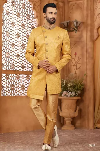 Gold indo-western sherwani set with full computer embroidery, coloured buttons, and thread, lace, and stone work.
