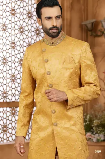 Gold indo-western sherwani set with full computer embroidery, coloured buttons, and thread, lace, and stone work.