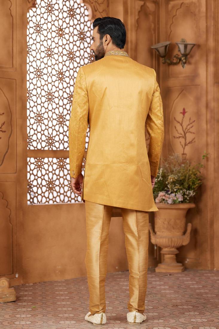Gold indo-western sherwani set with full computer embroidery, coloured buttons, and thread, lace, and stone work.