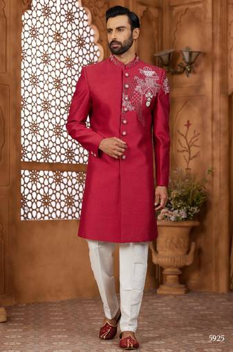 Red indo-western sherwani set with full computer embroidery, coloured buttons, and thread, lace, and stone work.